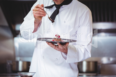 Chef putting chocolate sauce on a dessert