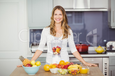 Portrait of cheerful woman standing at table