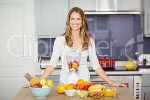 Portrait of cheerful woman standing at table