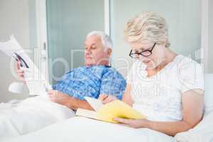 Senior couple reading on bed