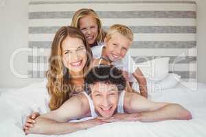 Portrait of smiling happy family on bed