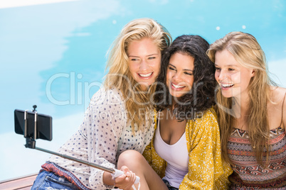 Beautiful women taking a selfie by swimming pool