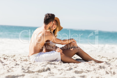 Young couple sitting on sand