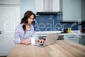 Young woman working on laptop while sitting at table