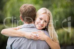 Smiling young woman hugging man