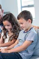 Father and siblings using digital tablet