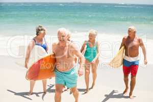 Seniors carrying surfboards at the beach