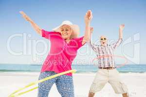 Senior couple doing hula hoop