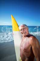 Senior man posing with a surfboard