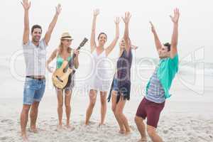 Group of friends playing guitar and dancing