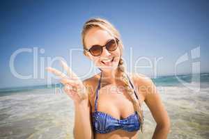 Happy woman showing victory sign on the beach