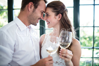 Couple toasting wine glasses in a restaurant