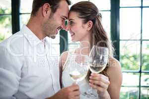 Couple toasting wine glasses in a restaurant