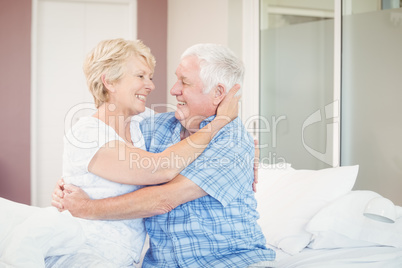 Senior couple embracing in bedroom