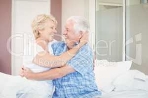 Senior couple embracing in bedroom