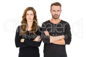 Upset couple standing with arms crossed