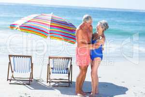 Cute mature couple hugging on the beach