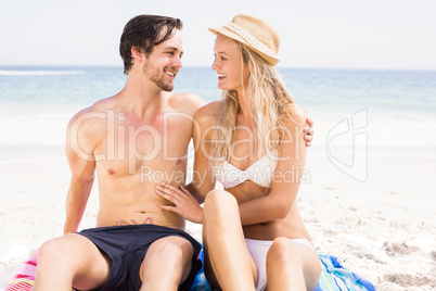 Young couple sitting and talking on the beach