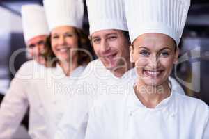 Happy chefs team standing together in commercial kitchen