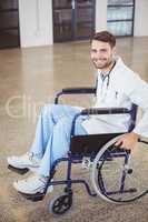Portrait of happy doctor sitting on wheelchair