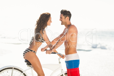 Couple posing with bike on the beach