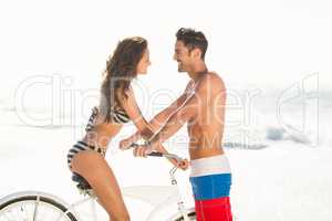 Couple posing with bike on the beach