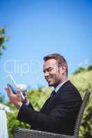 Businessman using tablet and having a coffee