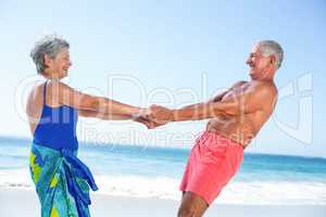 Cute mature couple holding hands on the beach