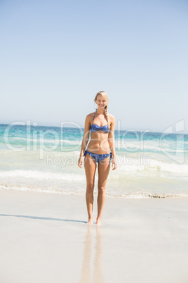 Happy woman in bikini standing on the beach