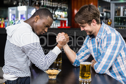 Happy friend arm wrestling each other