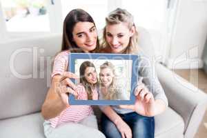 Young female friends taking selfei at home