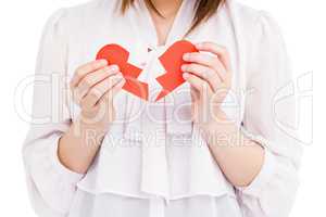 Young woman holding broken heart