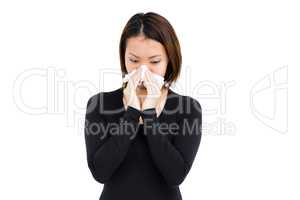 Sick woman blowing her nose with tissue paper