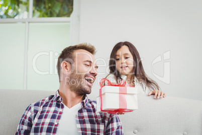Smiling daughter giving gift to father