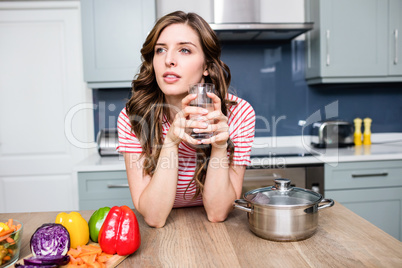 Thoughtful woman holding drinking glass