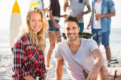 Couple sitting on sand at the beach