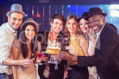 Happy friends celebrating birthday with cake