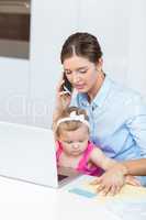Woman talking on mobile phone sitting with baby girl