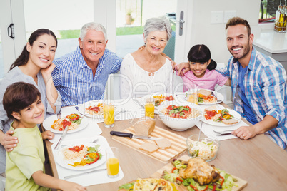 Portrait of smiling multi generation family with arm around