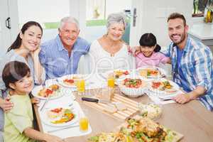 Portrait of smiling multi generation family with arm around