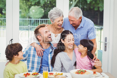 Smiling multi generation family at dining table