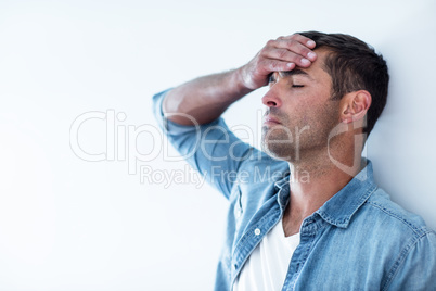 Upset man leaning on wall