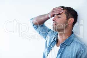 Upset man leaning on wall