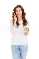 Happy young woman talking on mobile phone while having coffee