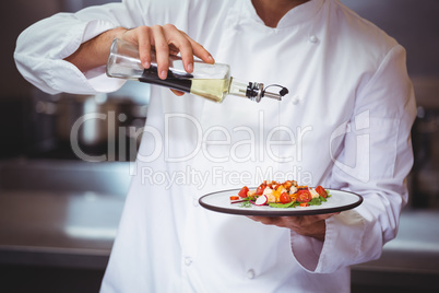 Chef putting finishing touch on salad