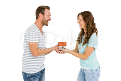 Happy young couple holding model house
