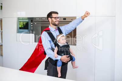 Father in superhero costume carrying daughter