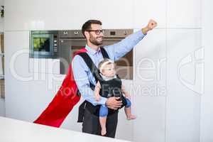 Father in superhero costume carrying daughter