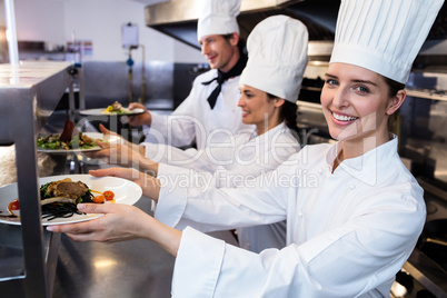 chefs handing dinner plates through order station