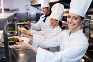 chefs handing dinner plates through order station